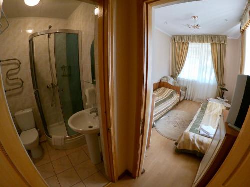 y baño con ducha, aseo y lavamanos. en Готель Мараморош, en Shayan