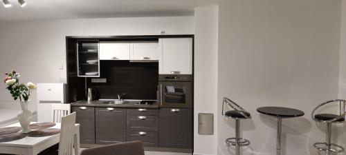 a kitchen with black and white cabinets and a table at Apartmán Mignon in Prachatice