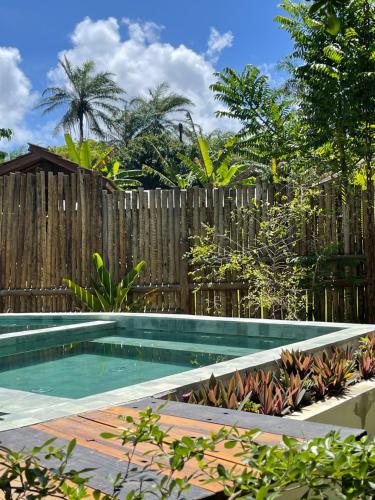 a swimming pool in front of a wooden fence at Maui Maui Wellness- Taipu de Fora - Barra Grande in Barra Grande