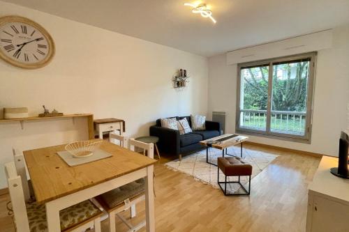 un salon avec un canapé et une horloge au mur dans l'établissement Sully II - Apartment of 33 sqm with parking 400m from Lake Annecy, à Annecy