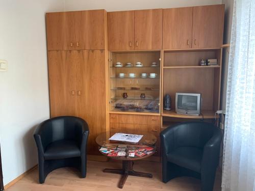 um quarto com duas cadeiras e uma mesa e uma televisão em Apartmány Bratislava em Bratislava