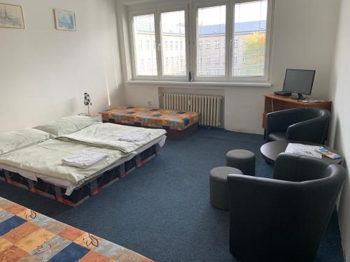 a room with two beds and a table and chairs at Apartmány Bratislava in Bratislava