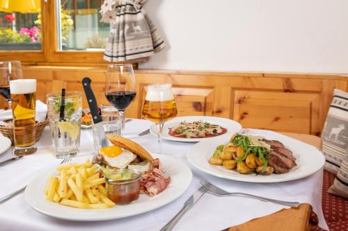 a table with three plates of food and glasses of wine at Randolins Familienresort in St. Moritz