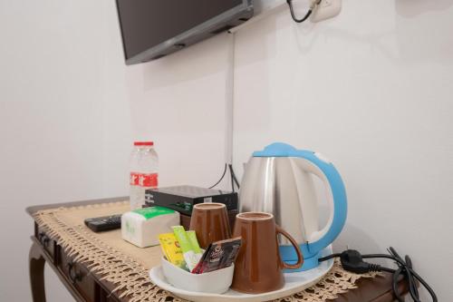 a table with a mirror and cups on it at RedDoorz Syariah near Summarecon Mall Bekasi in Kayuringin