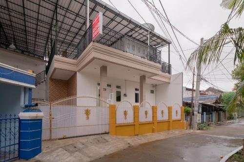 a building with a yellow gate in front of it at RedDoorz Syariah near Summarecon Mall Bekasi in Kayuringin