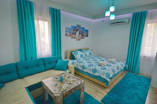a living room with a blue couch and a bed at Antonio Apartments in Ohrid