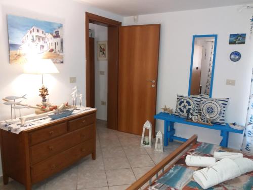 Un dormitorio con una cama, una cómoda y un espejo. en Appartamenti Baia Azzurra, en Leuca