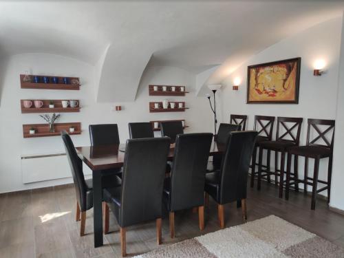 a dining room with a table and black chairs at Relax Lounge in Velké Meziříčí