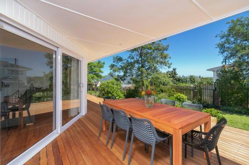 a porch with a wooden table and chairs at Paradise on Ridge in Knysna