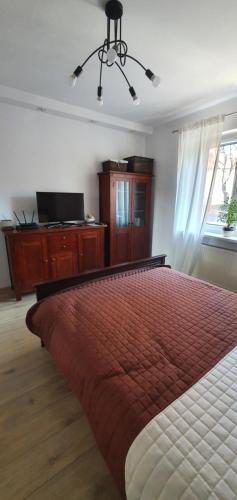 a bedroom with a bed and a television and a window at Apartament A&S Relax in Wałbrzych