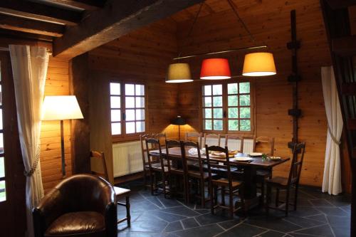 une salle à manger avec une table, des chaises et des lumières dans l'établissement chalet artheis, au Grand-Bornand