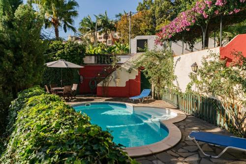 a swimming pool in a yard with trees and flowers at Quinta Florença - By WeHost in Funchal