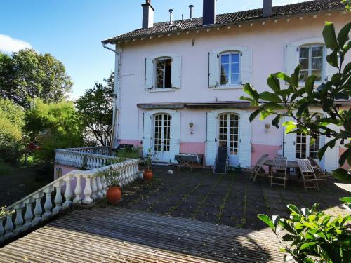 a large white house with a wooden deck at Le Clos de la Borde, chambre verte in Arches