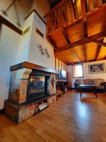 a living room with a stone fireplace in a house at Maison des Isard in Saint-Pierre-dels-Forcats