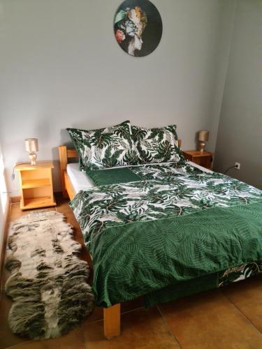 um quarto com uma cama com um edredão verde em Amina Apartman em Mórahalom