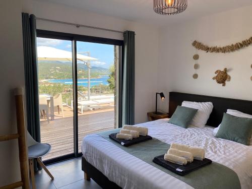 Schlafzimmer mit einem großen Bett und Meerblick in der Unterkunft Villa Pura Corsica with sea view and private pool in Conca