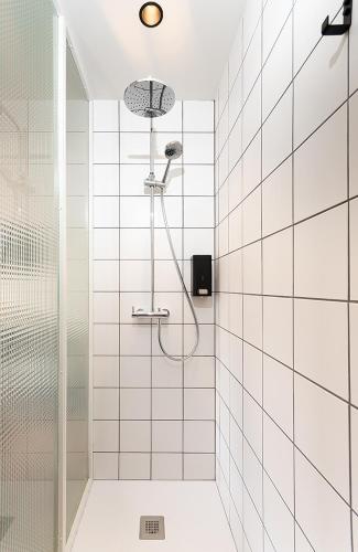 a shower in a bathroom with white tiles at "unic, turisme d'interior" in Andratx