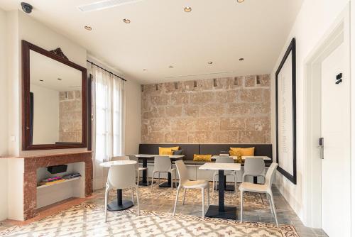 a dining room with tables and chairs and a brick wall at Unic - Turisme d'interior in Andratx