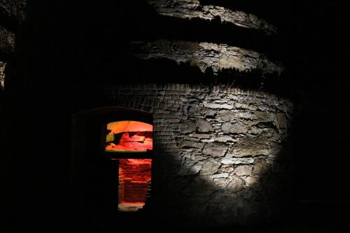 a window in a stone wall with a person holding an umbrella at Pensión NAVIA A Pontenova in A Pontenova