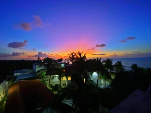 a sunset view of a house with palm trees at Sunset Paradise in San Andrés