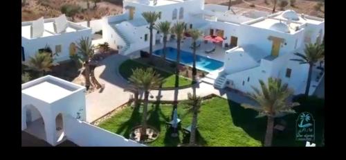 an aerial view of a large white house with palm trees at Dar El Jerbi in Mezraya
