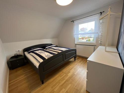 a small bedroom with a bed and a window at Ferienhaus LEMA in Schopfloch