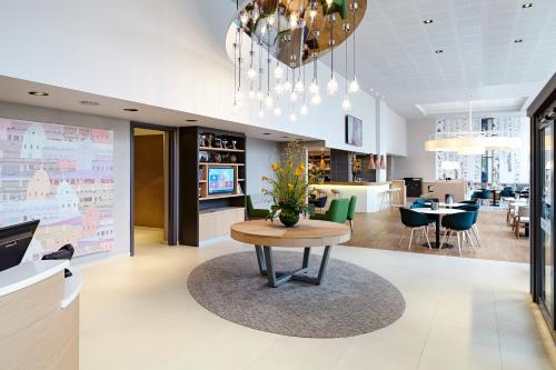 a lobby with a table and a dining room at Novotel London Wembley in London
