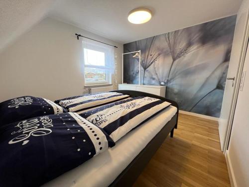 a bedroom with a bed with black and white comforter at Ferienhaus LEMA in Schopfloch