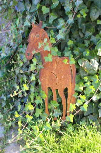 a small red horse statue in the grass at Ponyhof Adam Urlaub auf dem Bauernhof in Eschlkam