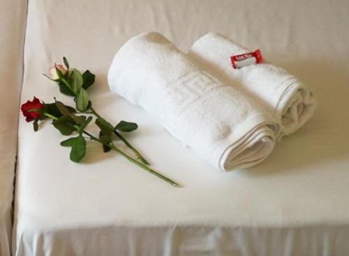 a white book and a rose on a bed at Iliana's house in Naousa