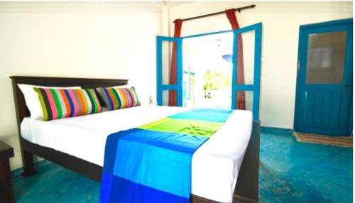 a bedroom with a bed and a blue door at Seth Villa by Magampura Resorts in Tangalle