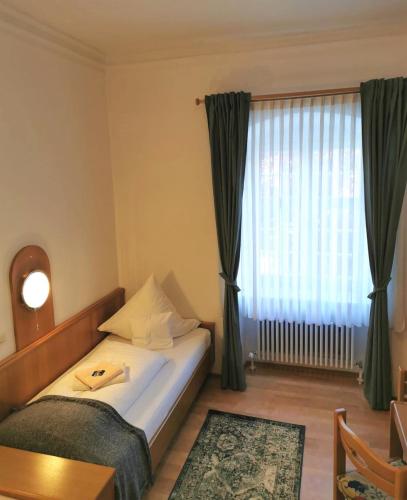 a hotel room with a bed and a window at Gästehaus Reisinger in Straubing