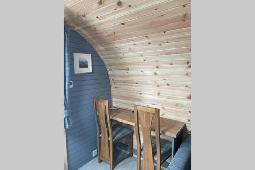 a wooden dining room with a table and chairs at Sea Breeze Pod in Fort William