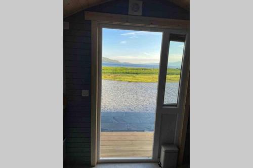 a door open to a view of a lake at Sea Breeze Pod in Fort William