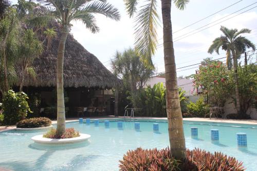 a swimming pool with palm trees and a resort at Ecotel Quinta Regia in Valladolid