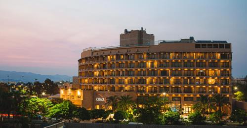 a building with lights on in a city at night at Oryx Hotel Aqaba in Aqaba