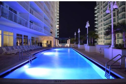 a large swimming pool in a building at night at Brickell Apartments with Oceanview in Miami