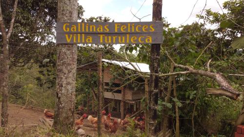 a sign with chickens in front of a house at Green Hostal Popayan in Popayan