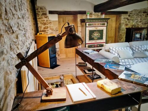 a lamp on a table in a living room at Maison en Pierre in Fiastra
