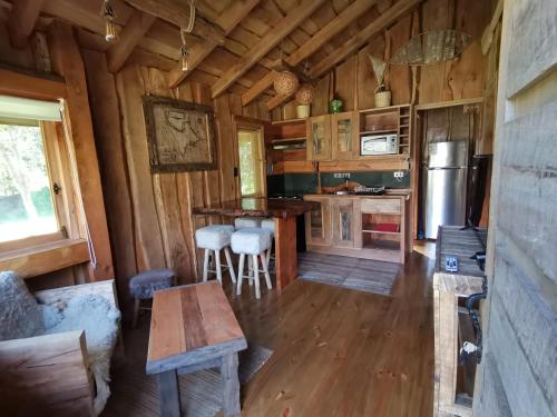 a kitchen with a table and chairs in a cabin at Cabaña Rústica Pellin in Pucón