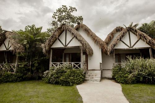a house with a palm tree in front of it at Playa Venao Hotel Resort in Playa Venao