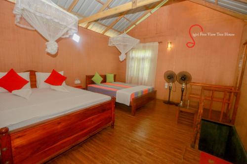 a bedroom with a bed and a table with a fan at Sigiriya Free View Tree House & Villa in Sigiriya