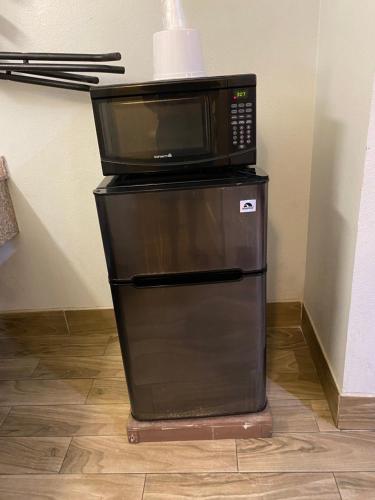 a microwave sitting on top of a refrigerator at Welcome Inn Corona in Corona