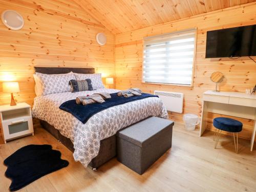 a bedroom with a bed in a wooden cabin at Castle View Lodge in Derby