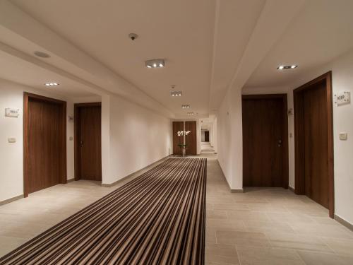 a hallway with brown doors and a striped carpet at Aparthotel Miramare in Makarska