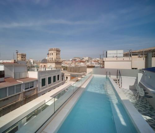 a swimming pool on the roof of a building at Dormirdcine Alicante in Alicante