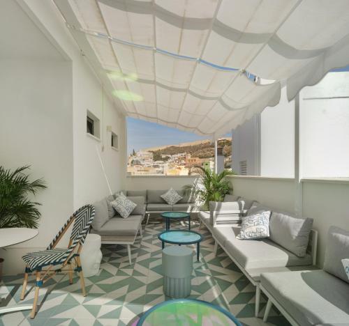 a living room filled with furniture and a balcony at Dormirdcine Alicante in Alicante