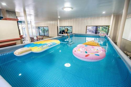 a large swimming pool with a inflatable pool at Vanilla house heart of Sattahip in Sattahip