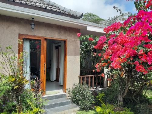 a house with pink flowers in front of a door at Terrasse du Lac Munduk in Munduk