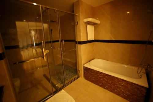 een badkamer met een douche en een bad bij The Grand Mountain Hotel in Matale